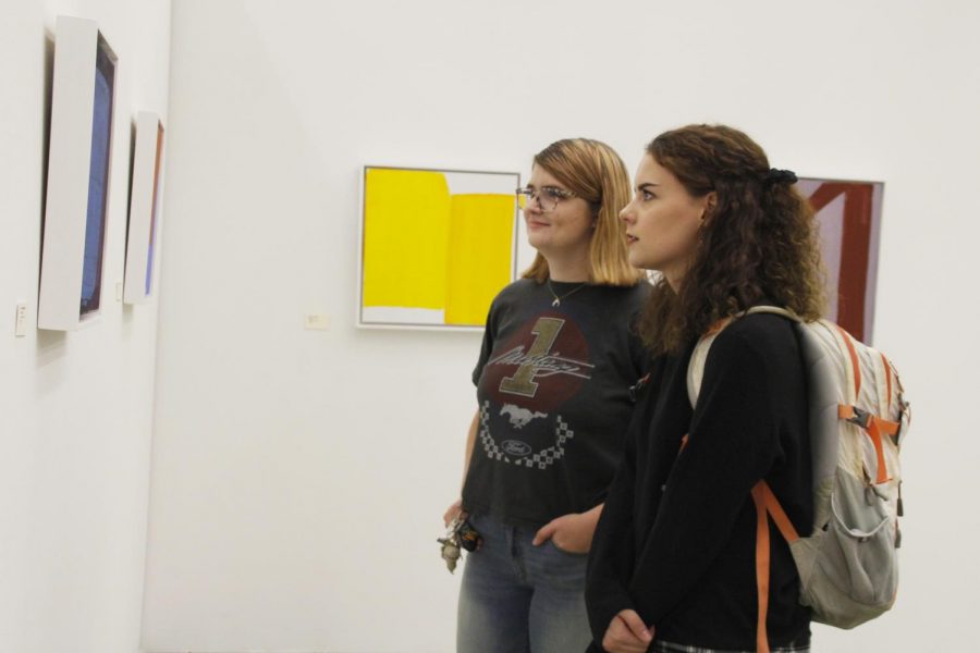 Leia O’Connell, a senior kinesiology major, and Katherine Davis, a senior sociology major, check out the abstract artwork for the Contemporary Art Gallery’s opening reception of the “Real to Not Real” exhibition. 