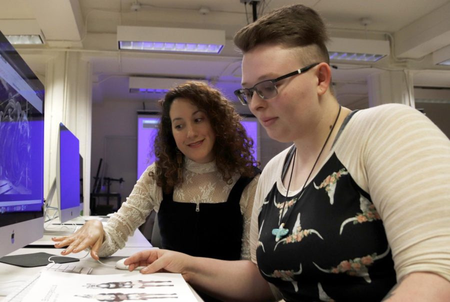 Cristina Molina, assistant professor of new media and animation, shows Sierra Arbaugh, a sophomore art major, works by Louise Bourgeois in class. Inspiration from her mom, aunts and grandmothers helped Molina grow in her artistic endeavors. 