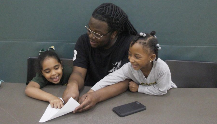 Cameron Wood, a sophomore business administration major, helps two kindergartners with their homework. This contributes to the goals of the “Rec Kids After School Program.” 