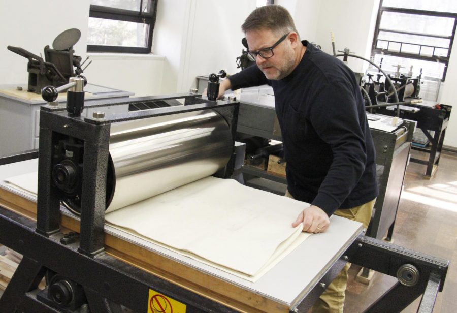 Ernest Milsted uses one of the printmaking machines located in Clark Hall room 303. His passion for photography, printmaking and the creativity of his students serves as an inspiration for his art. 