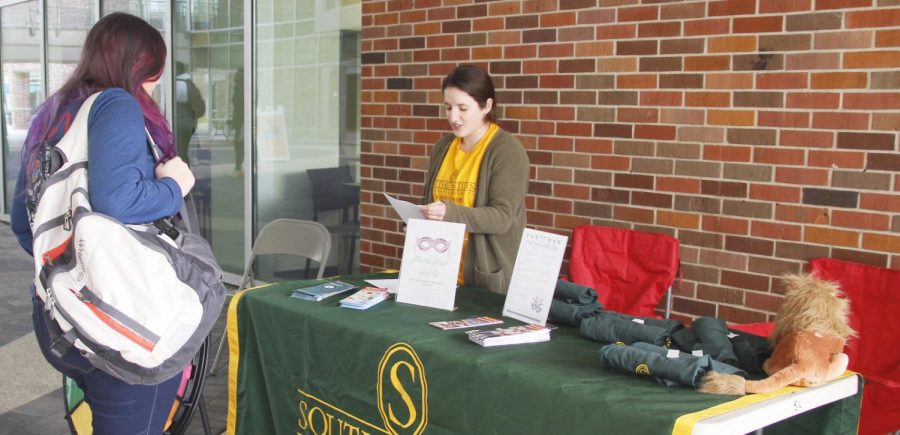 Eryn Brannagan, a senior health education and promotion major, offers students tips about safety during Mardi Gras in the Student Union Breezeway on Feb. 25. The informational session included a game where students could answer questions about safety and win a T-shirt. 