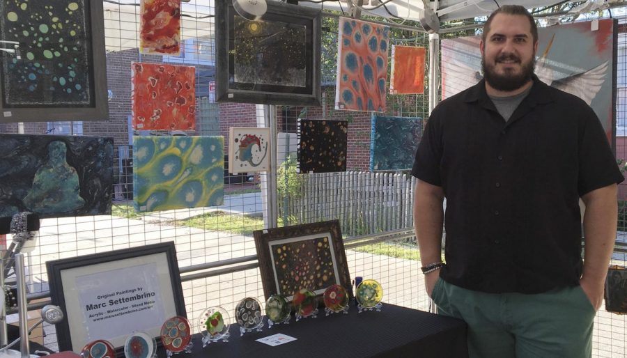 Dr. Marc Settembrino, assistant professor of sociology,  poses with his artwork. Through the Hammond Art Guild, Settembrino advertises his art to the community. 