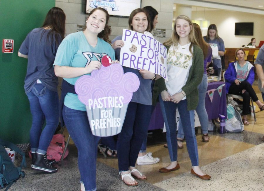 Members of Sigma Sigma Sigma sorority promote their bake sale with posters. 100 percent of the funds raised supported the sororitys philanthropy. 