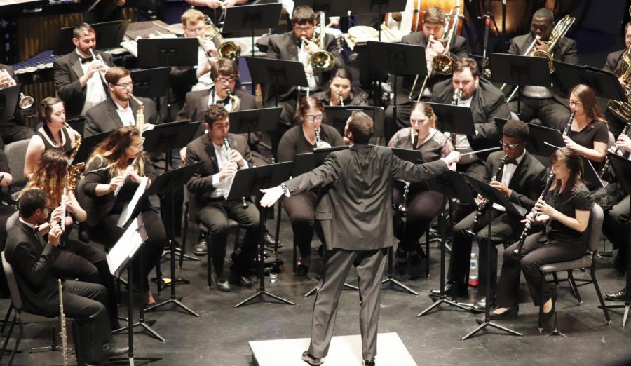 Derek Stoughton, conductor of the Wind Symphony, directs the performers in a concert that calls back to the medieval renaissance. The concert was the symphonys last production of the season.