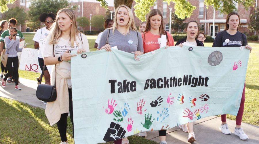 Students carry signs as they march around campus for Take Back the Night Rally. The event aimed to bring more awareness to sexual assault on college campuses. 