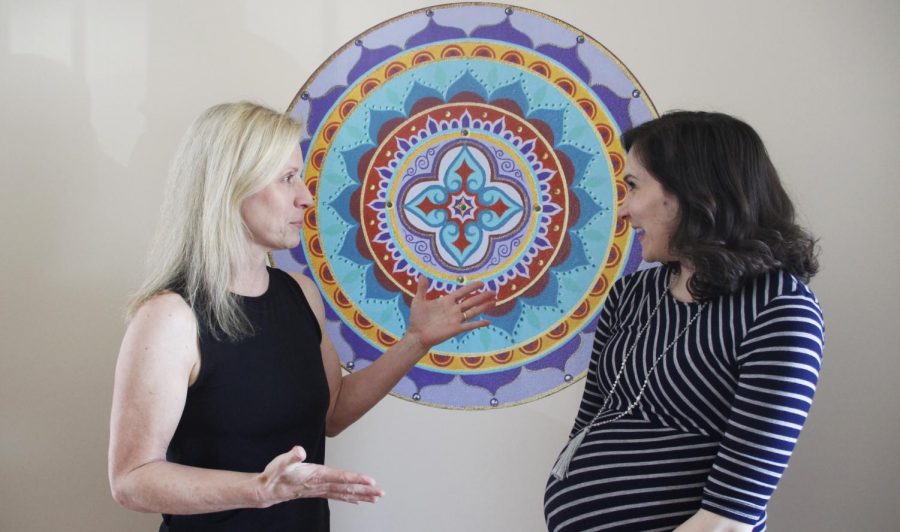 Breanna Barzenick, co-owner and instructor of Downtown Yoga, discusses “Geaux Yoga” with Erica Kelt, Northshore director of development for the Mary Bird Perkins Cancer Center. The event is intended to benefit cancer patients and their families. 