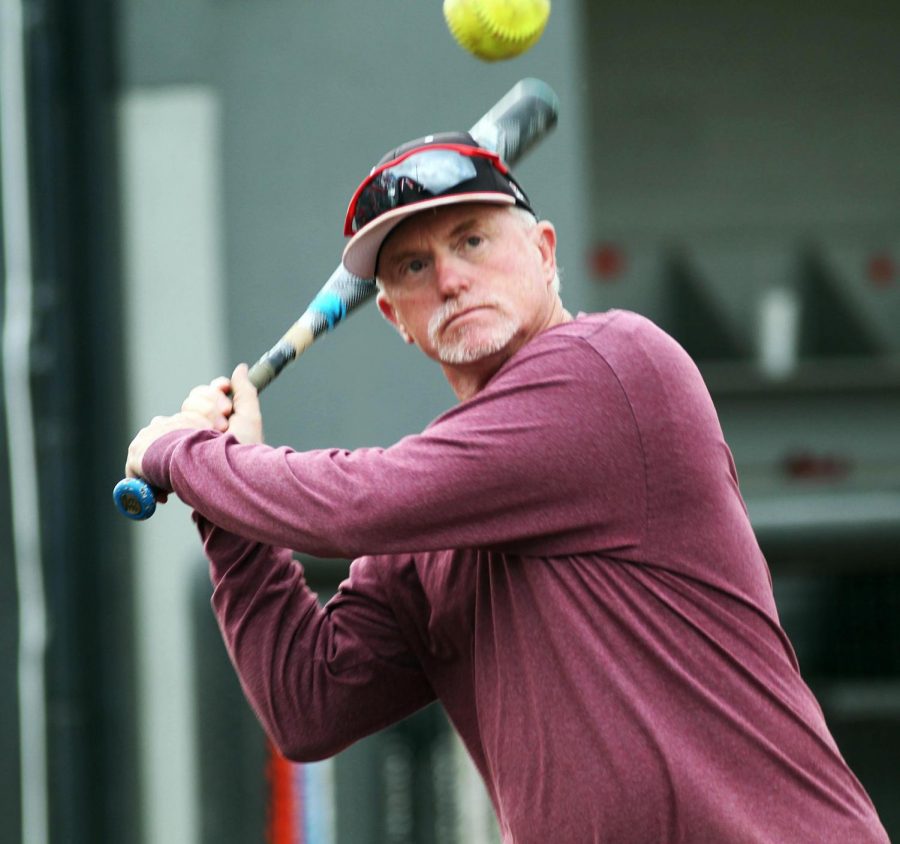 Jack Byerley, assistant softball coach, winds up the bat at practice. Byerley, armed with decades of coaching experience from schools around the nation, has recently joined the Lions softball coaching staff. 