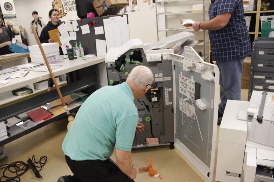 Workers set up the new printing equipment at The Document Source. The office serves students and faculty with their printing and mailing needs.
