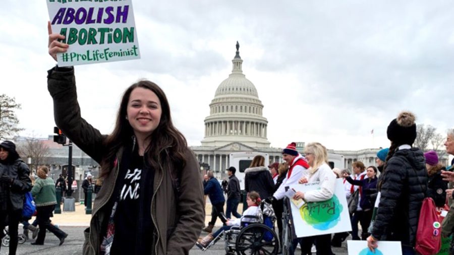 Taylor Gautreaux, coordinator for the Louisiana Students for Life trip, poses with a sign in front of the Capitol Building during March for Life 2020. 