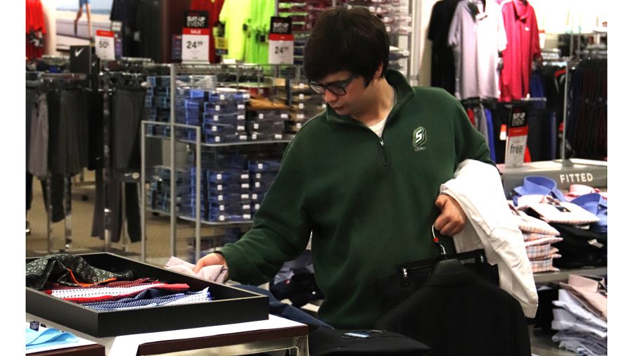 A student browses clothing item during the J.C. Penney Suit Up event. The event is designed to help students dress up professionally for career fairs and interviews.