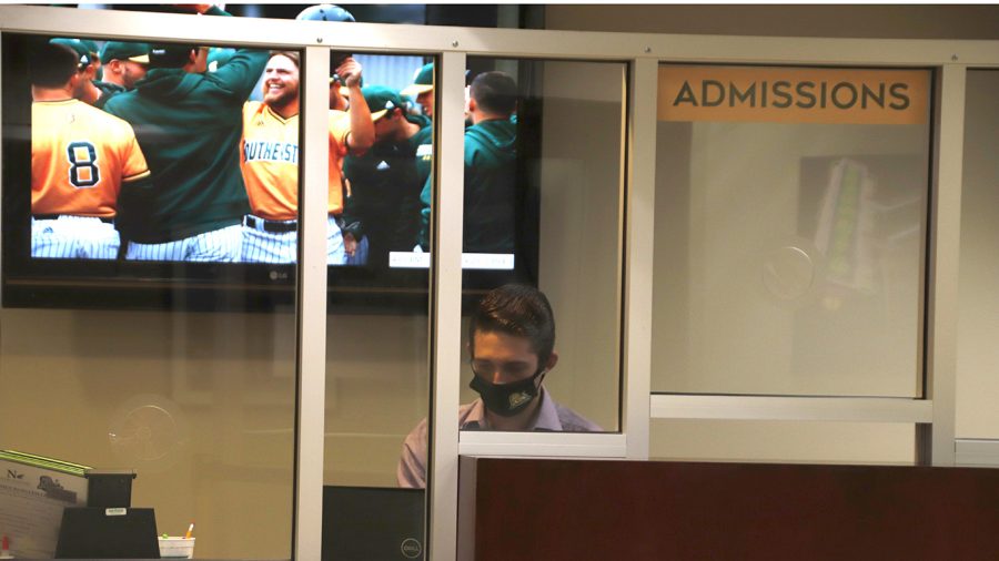 Student worker at the Office of Admissions wears mask at the front desk. Offices on campus have resumed their normal operation after following the campus safety guidelines. All individuals are required to wear masks inside campus buildings.