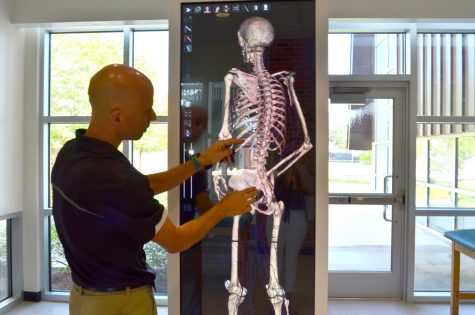 Dr. Ryan Green, assistant professor of kinesiology and health sciences, demonstrates the use anatomage table. An anatomage table is an advanced virtual 3D dissection table that allows a better view of the human anatomy.