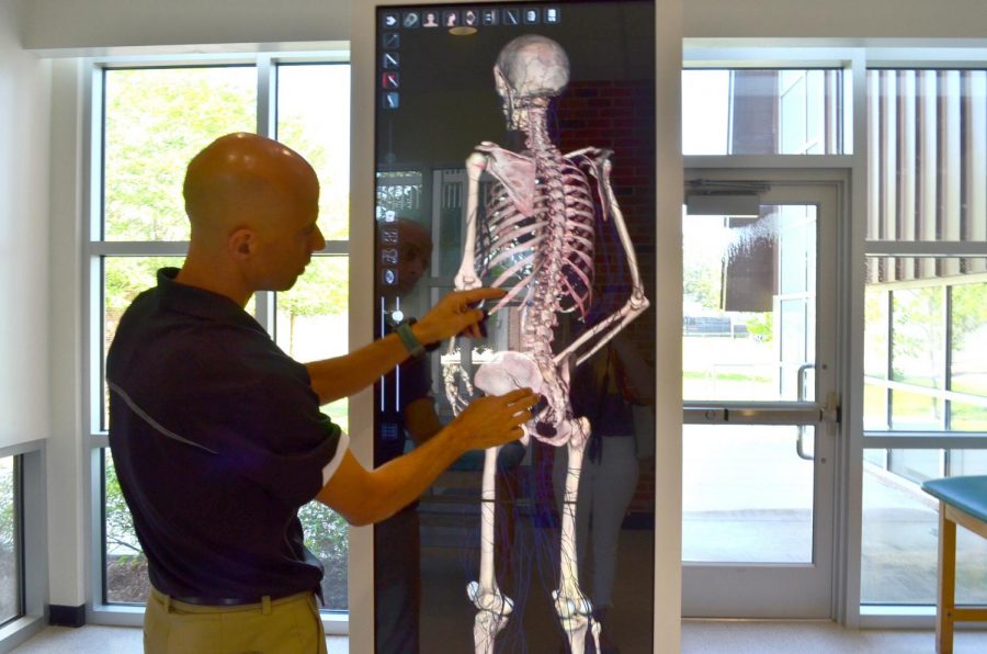 Dr. Ryan Green, assistant professor of kinesiology and health sciences, demonstrates the use anatomage table.  An anatomage table is an advanced virtual 3D dissection table that allows a better view of the human anatomy.