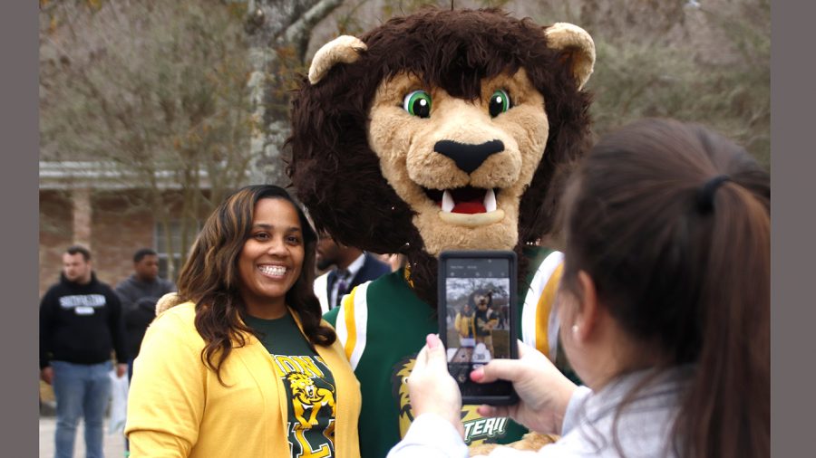 A university alumni poses with Roomie the Lion at the  2019 Lion 4 Life party. Being a member of the Alumni Association grants graduates access to a variety of social and networking events.
