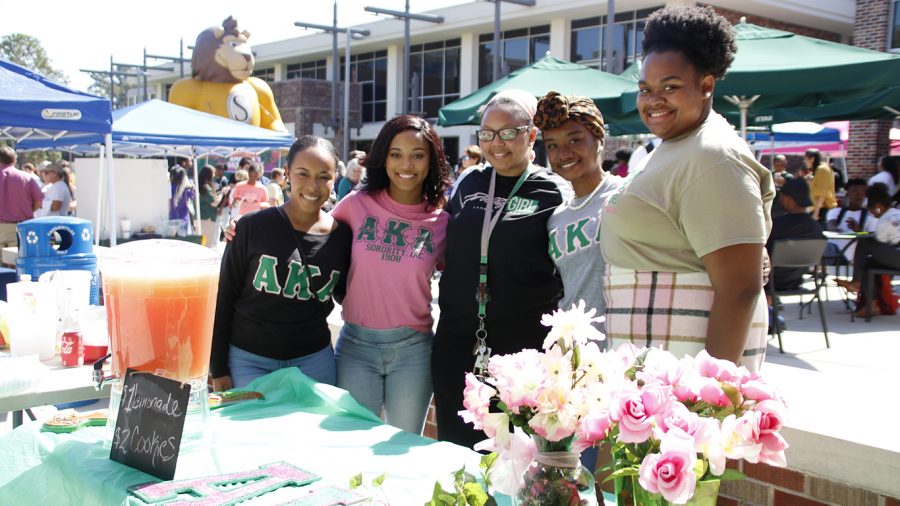 Members of Alpha Kappa Alpha sorority pose for a picture in front of their lemonade stand during Gumbo YaYa 2019.