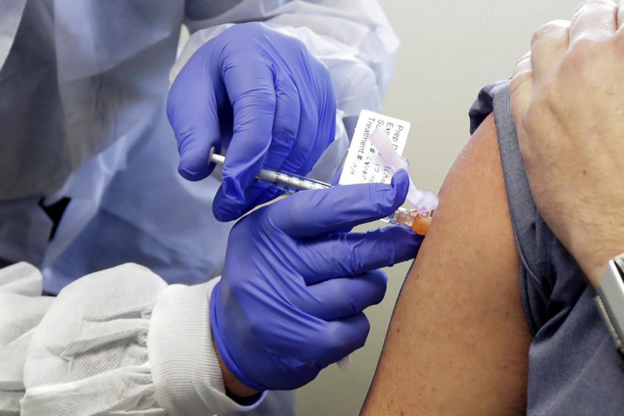 Neal Browning receives a shot in the first-stage safety study clinical trial of a potential vaccine for COVID-19, the disease caused by the new coronavirus, Monday, March 16, 2020, at the Kaiser Permanente Washington Health Research Institute in Seattle. Browning is the second patient to receive the shot in the study. 