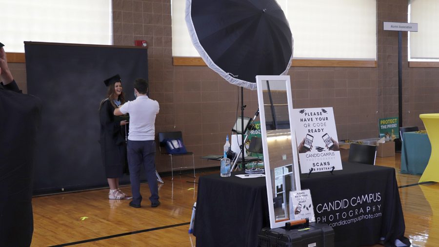 A Candid Campus photographer helps a student pose for her graduation photos during Grad Fair. Students who missed
out on Grad Fair will be able to take a make up photo by making an appointment before 10 a.m. on Nov. 16.