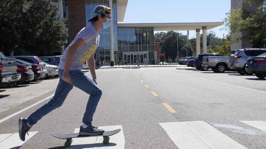 Trevor+Tolar+skates+across+the+crosswalk+in+front+of+Sims+Memorial+Library.+A+number+of+students+use+various+modes+of+transportation+to+get+around+campus.+