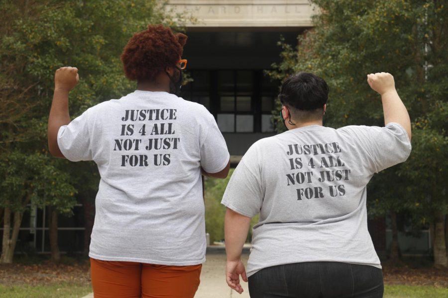 Justice4Alls President Michaela Thorpe (right) and Vice President Lynzeryus Railey (left) display their solidarity for social justice advocacy. Both officers are graduate students in the universitys applied sociology program. They are wearing T-shirts that were given out at the J4A meeting on March 24.