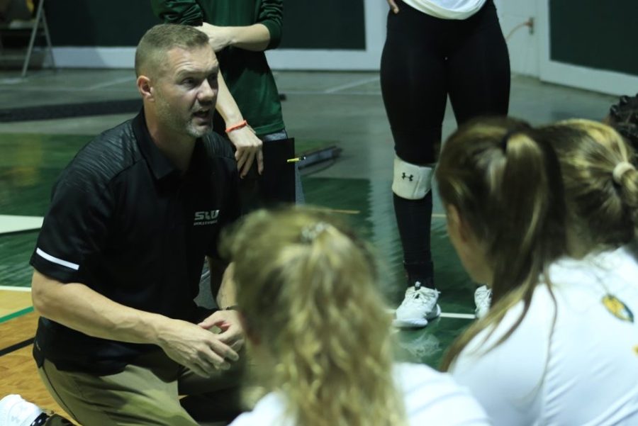 Head Coach Jeremy White speaks with players between sets during Thursdays game against Nicholls State University.