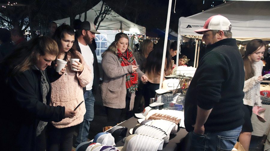 Guests view a vendors booth in Downtown Hammond during Starry November Night in 2019 while drinking hot chocolate. 