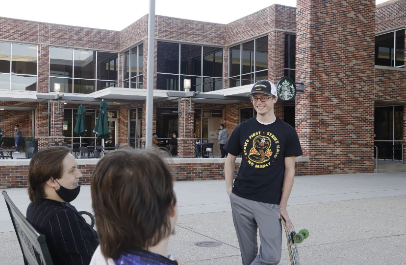 Three students gathered in front of the Student Union talking. Student organizations recently had to deal with postponing their on campus events for several days.