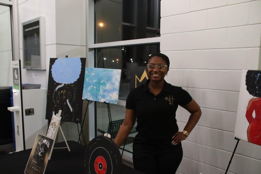 Kourtni Harris posing with her pieces titled Distinction.