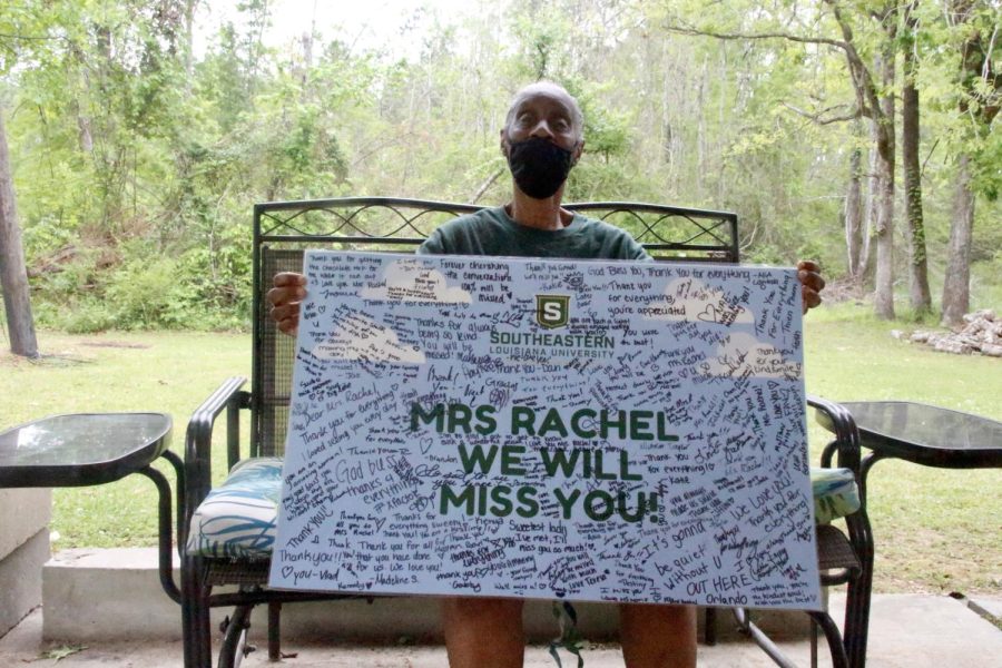 Washington holds a banner gifted to her when she retired. The banner is signed by faculty, staff and students.