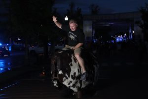 A Hot August Night attendee rides shows his skills on a mechanical bull. 