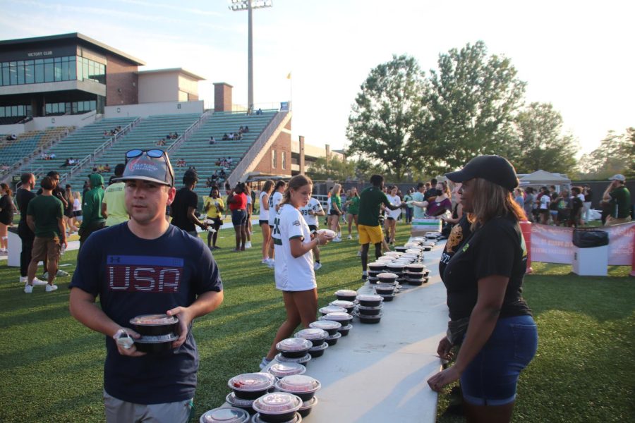 Students grab servings of pasta provided by Olive Garden at Strawberry Stadiums football field.