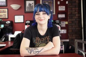 Senior marketing major Zoe Burns sitting at the front in Monsters Ink. Burns leads a busy life as a full time student at SLU and a tattoo apprentice. 