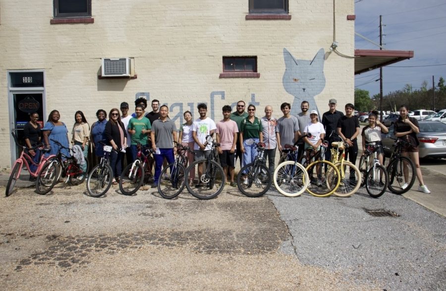 International students stand with their new bikes alongside member of the community who made the giveaway possible.