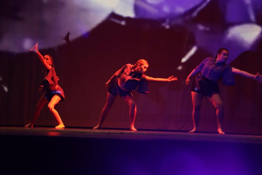 Three dancers take centerstage and use their movement as a form of expression. 