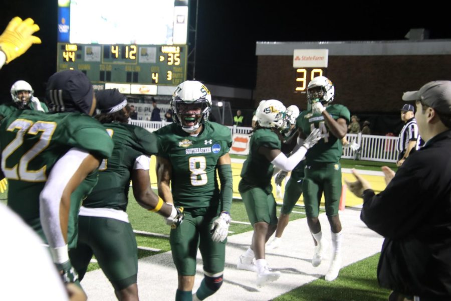 Southeastern players celebrate on the sideline following #14 Zy Alexander's fourth quarter pick six. (Nov. 26, 2022)