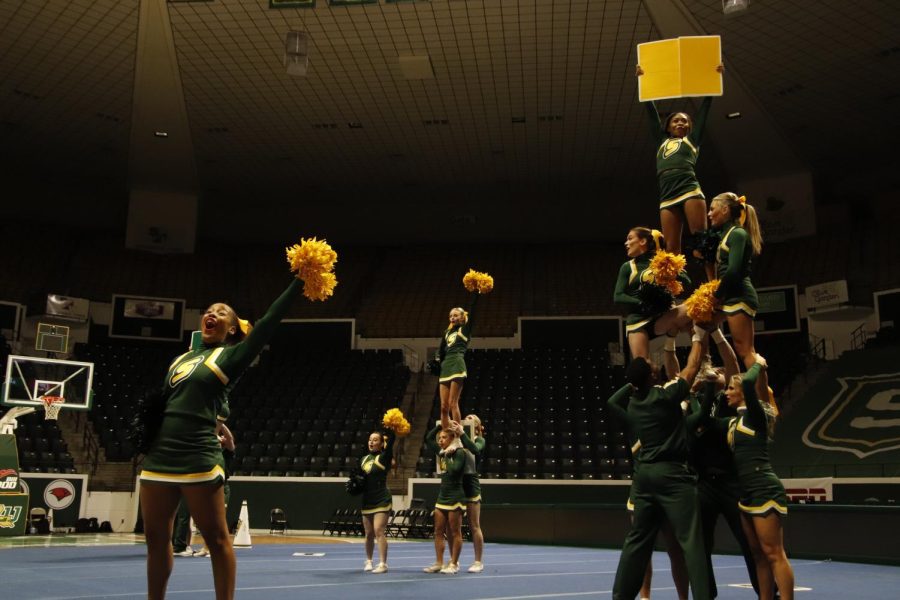 SLU cheer squad works the crowd in a sideline chant through signs, poms, shoulder stands and two tier stunts.