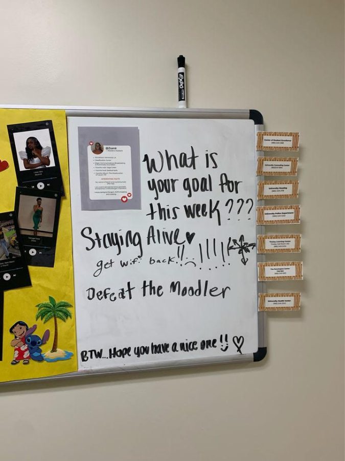 A dorm hall's whiteboard where a student has written "Defeat the Moodler" to bring a sense of humor to the theories students have been making.