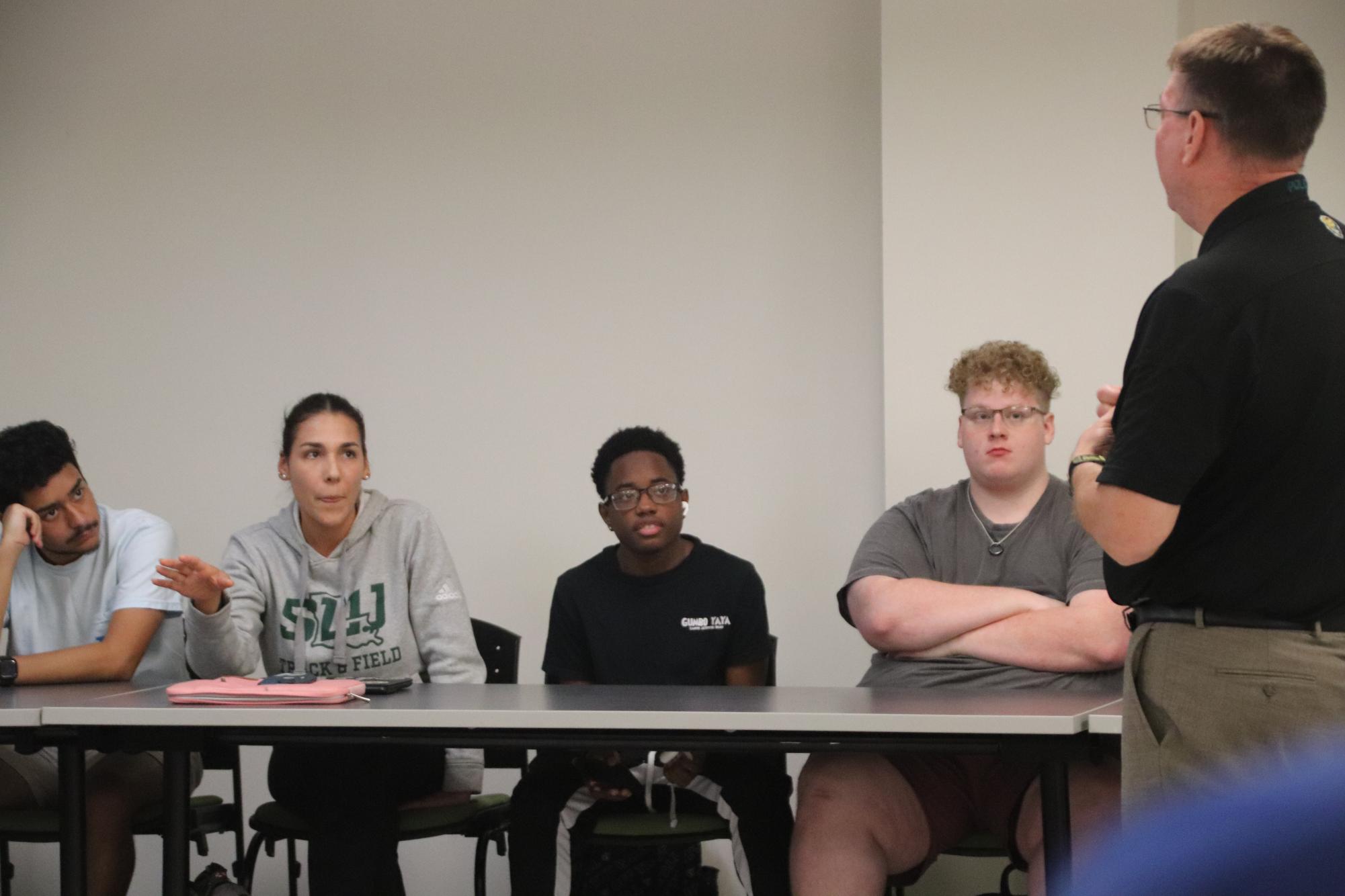 Thais Lindemayer Gomes, a second-year graduate student studying health promotion, asks Chief Michael Beckner a question as her peers listen intently. 