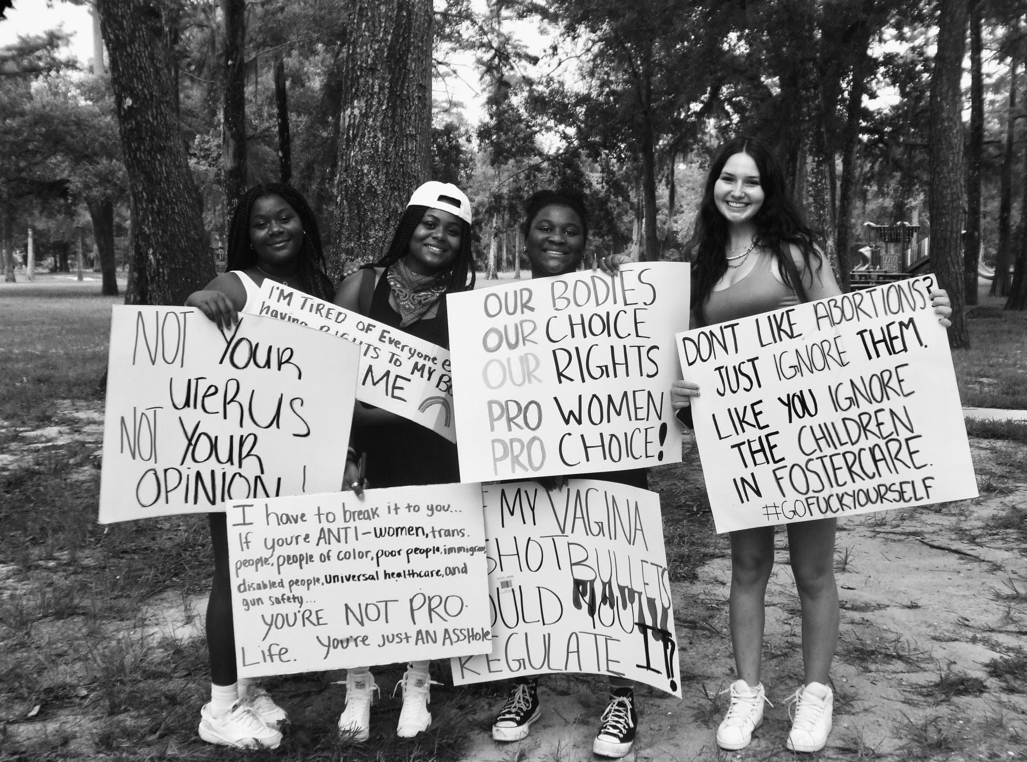 A group of young women present their opinions via posters on the overturn of Roe v. Wade around the time of its happening. 