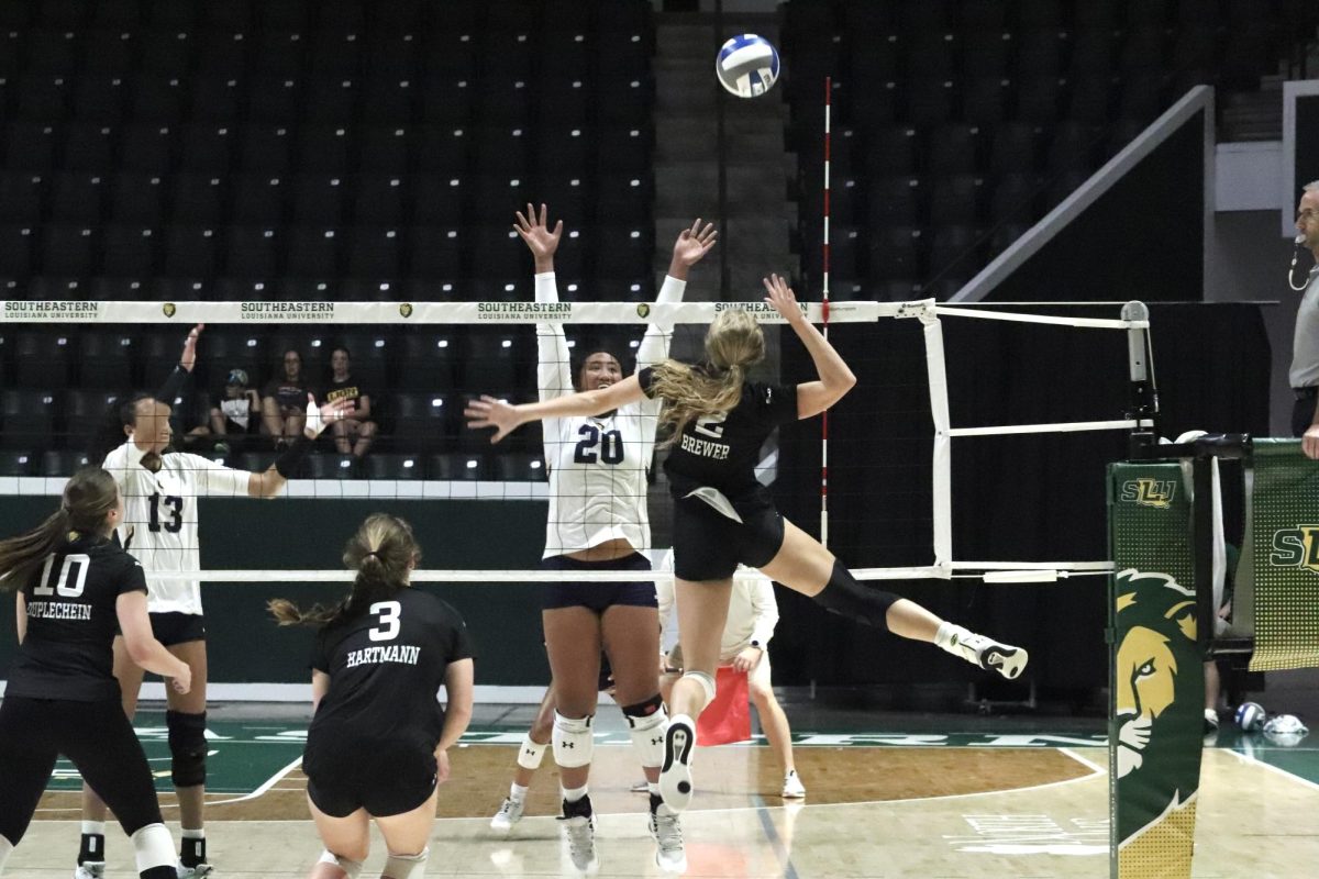 Junior middle hitter Hannah Brewer (2) attempts spike over Texas A&M-Commerces Kitana Tuufuli (20). (Sept. 30, 2023 - Hammond)