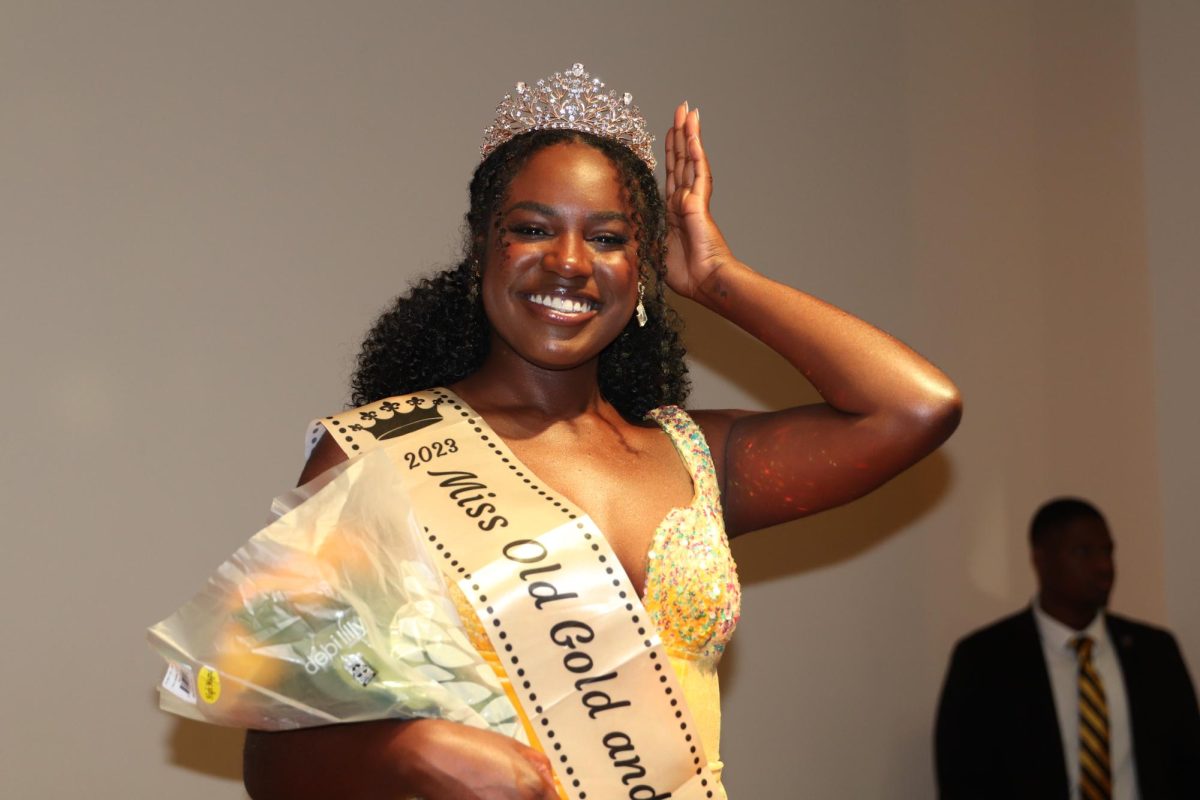 The newly crowned Miss Black and Gold Zsane Wicker doing a walk around the stage with her crown and bouquet at the pageant.