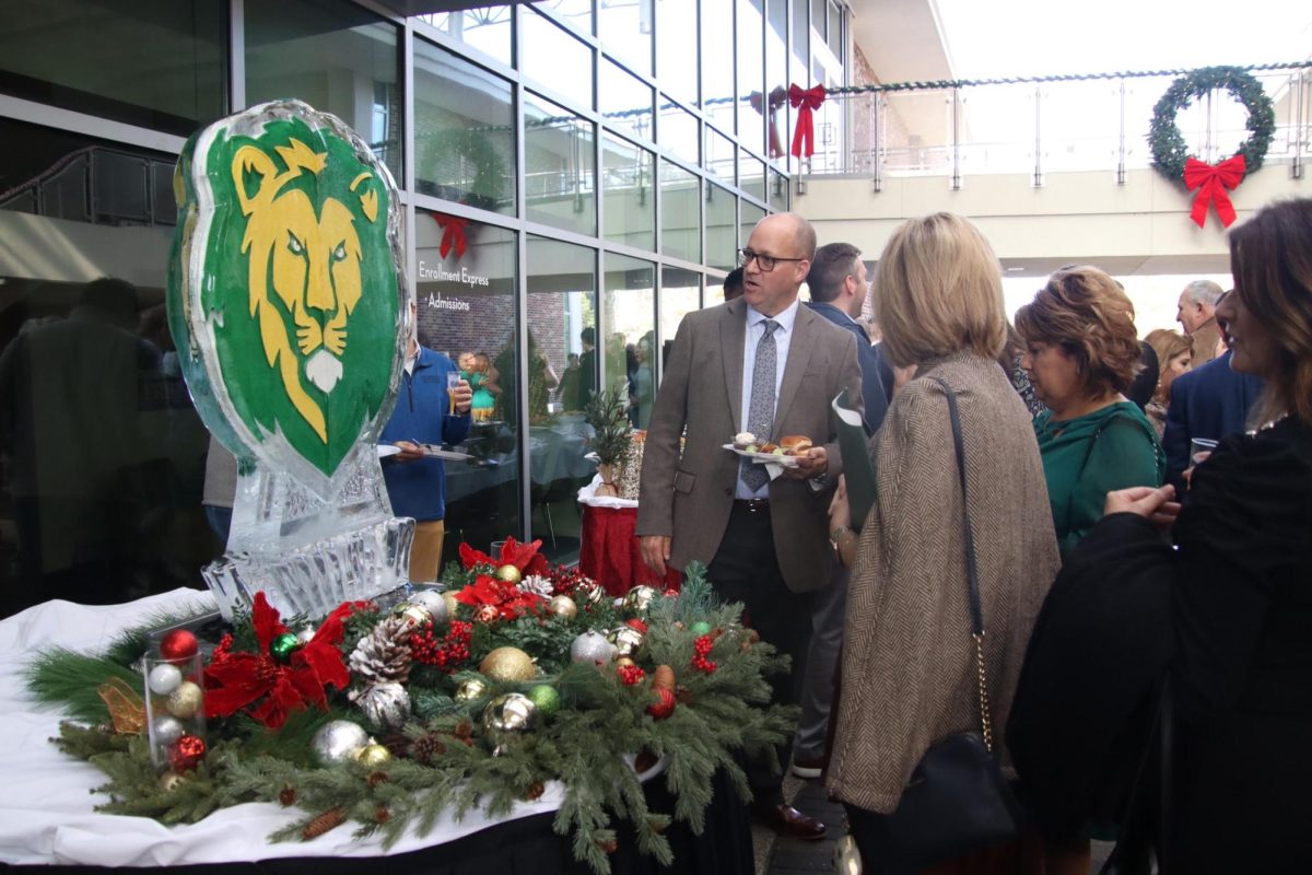 An attendee of the investiture brunch taking a look at the SLU themed ice sculpture. 