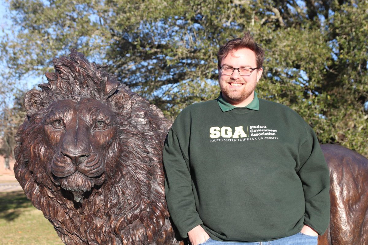 Bailey Milburn, a senior mathematics major and chief justice of SGA, poses in front of the lion statue in friendship circle. 
