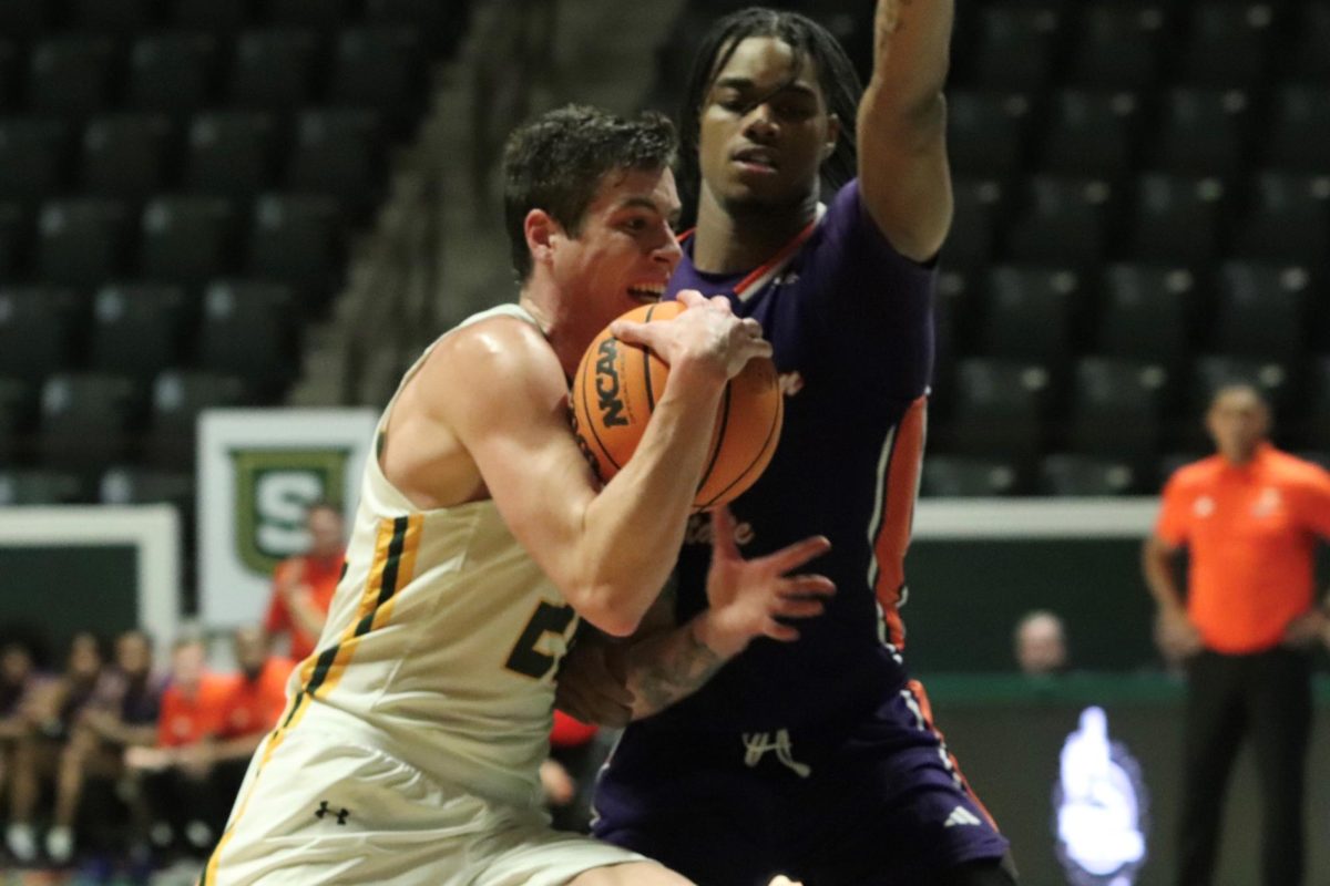 Senior SLU guard/forward Nick Caldwell puts his head down and drives to the goal on Northwestern State defender at the Pride Roofing University Center. (Jan. 22, 2024 - Hammond) 
