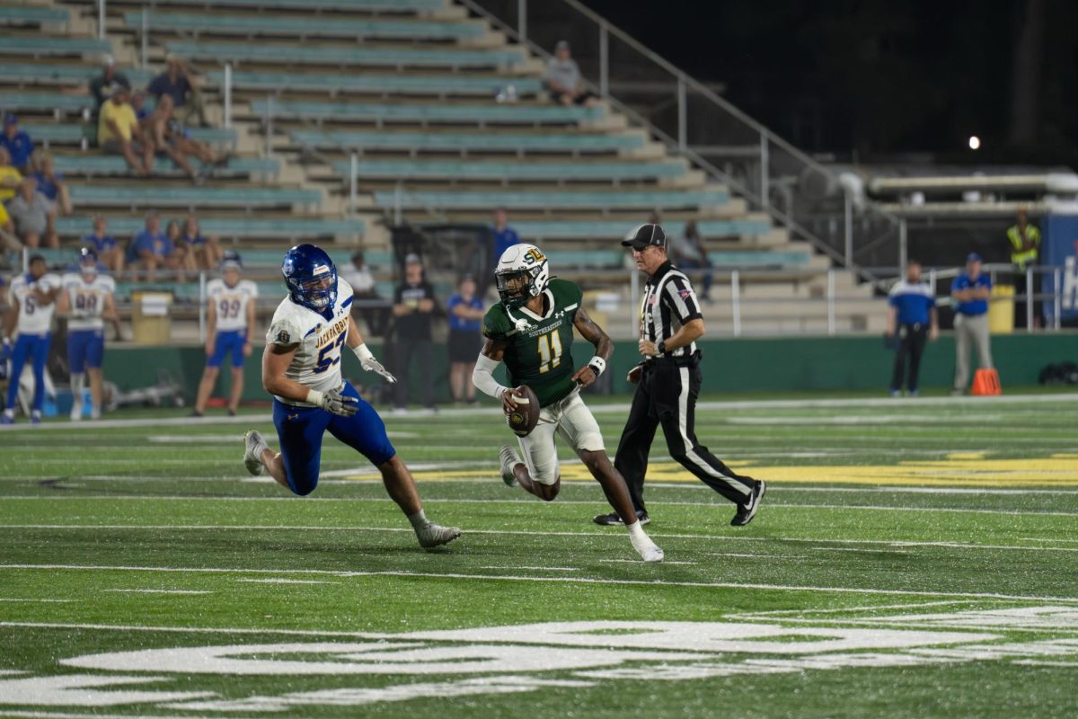 Junior quarterback Damon Stewart scrambles outside the pocket, racing for a lane while the Jackrabbits defender lurks just behind him. (Hammond, LA - Sept. 21, 2024)