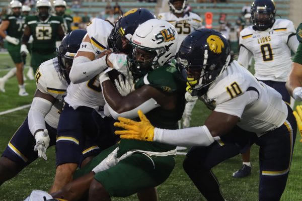 Sophomore running back Antonio Martin Jr. runs between two Texas A&M-Commerce defenders. (Hammond - Oct. 5)