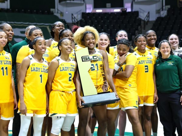 The Lady Lions lift up the trophy, celebrating their 2025 SLC reglar season title.