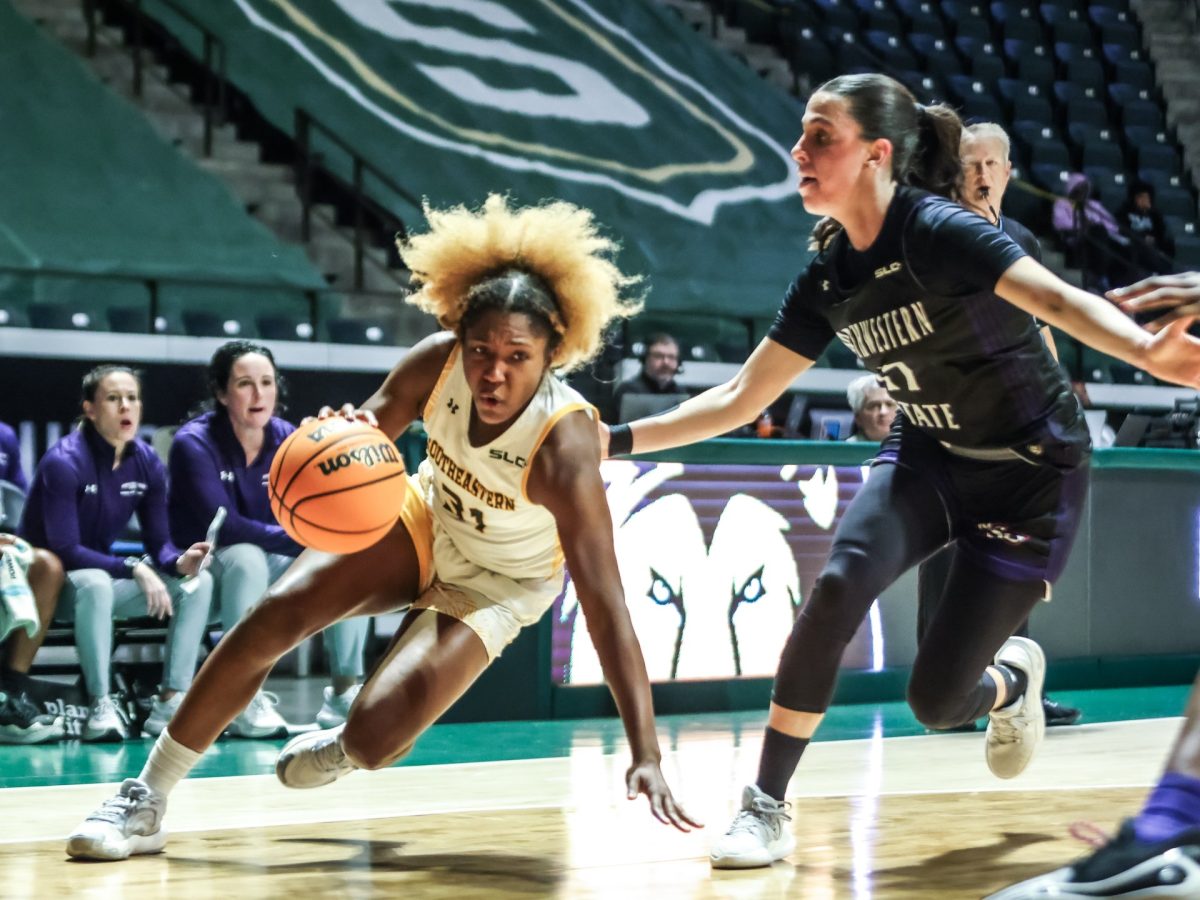 Graduate Lady Lions guard Alexius Horne maintains her balance while driving baseline around Demon defender. 