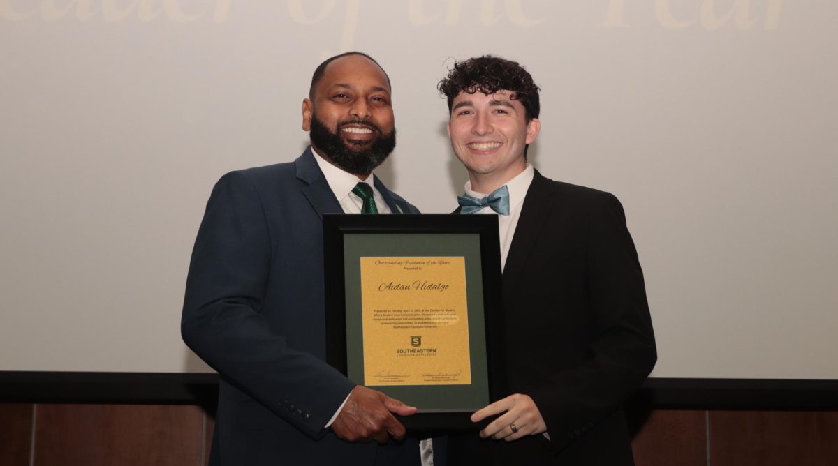 Dr. Eric Summers, vice president for student affairs, presents freshman health systems management major Aidan Hidalgo with the Outstanding Freshman of the Year award at the 2024 DSA Awards Convocation. 