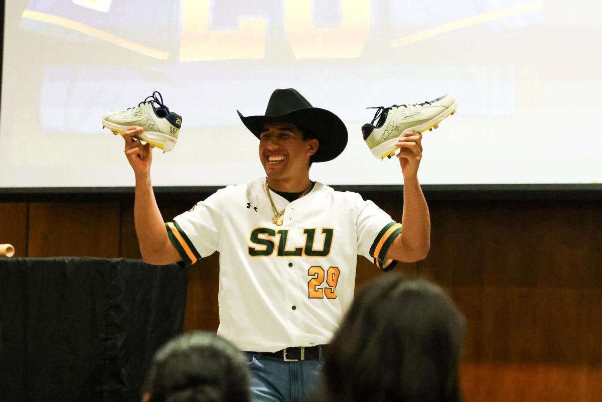 Junior pitcher Tony Torres holds up two signed cleats during the baseball team's annual fundraising gala.