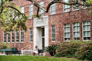 A student sits outside Meade Hall. (April 7, 2025)